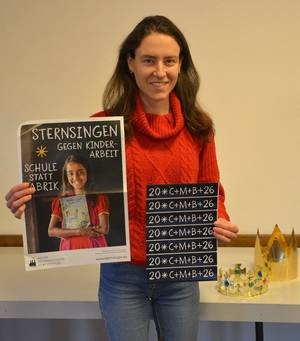 Lisa Lauer mit Aufklebern und Sternsingerplakat